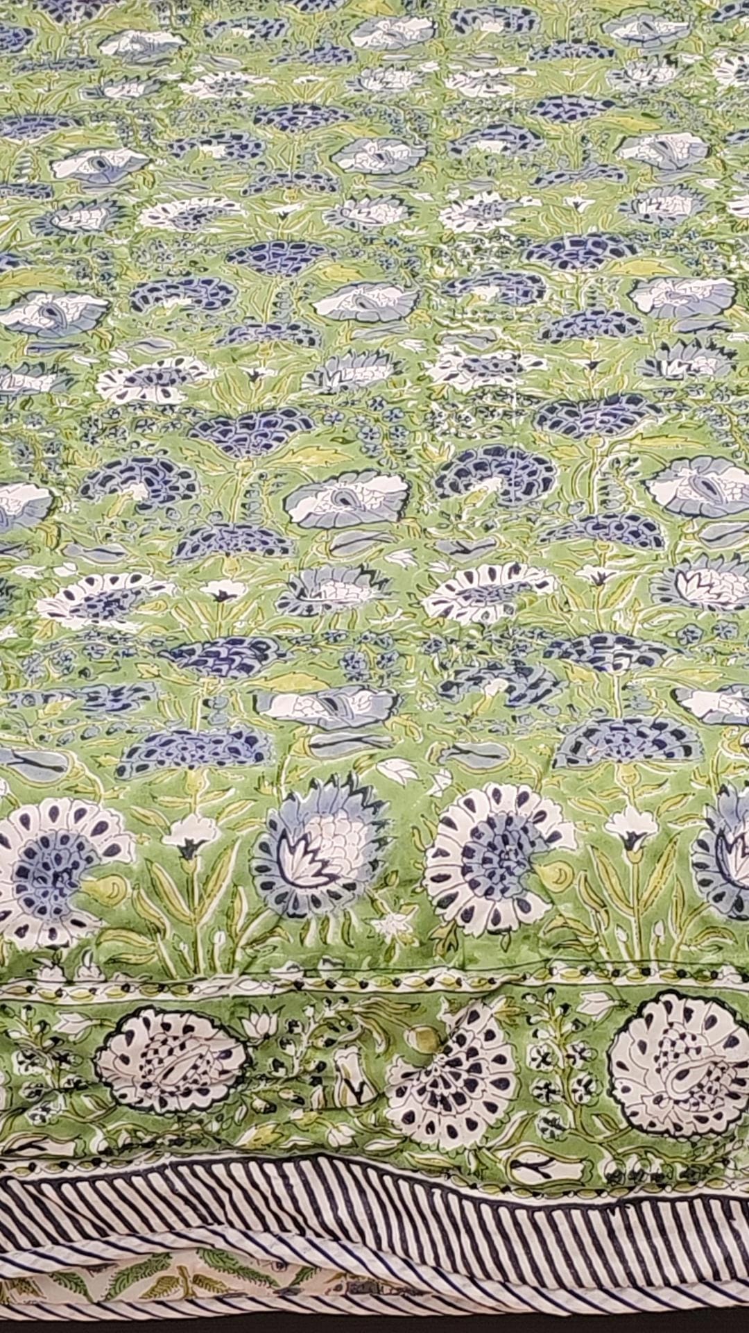 "Emerald Blooms: Green Floral Quilt with a Hint of Blue Flowers"